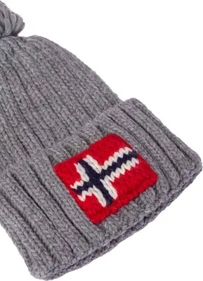 A close-up of a knitted beanie with a Norwegian flag patch.