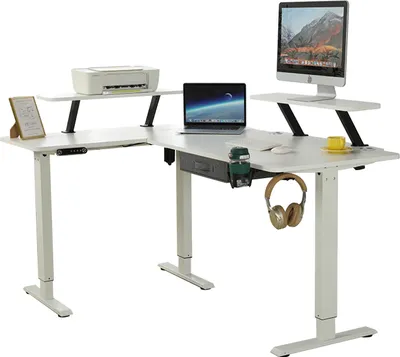 A white L-shaped standing desk with a laptop, monitor, printer, and headphones.