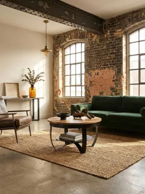 Eleganter runder Couchtisch aus Mango Massivholz und schwarzem Metall in einem stilvollen Loft-Wohnzimmer, dekoriert mit Vasen und Schalen._#sku_SAFWL6.327#