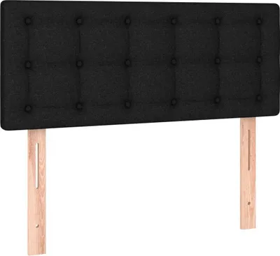 A black upholstered headboard with wooden legs against a white background.