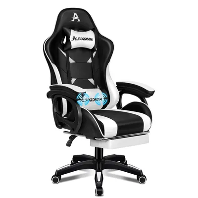 A black and white gaming chair with a footrest and lumbar support.