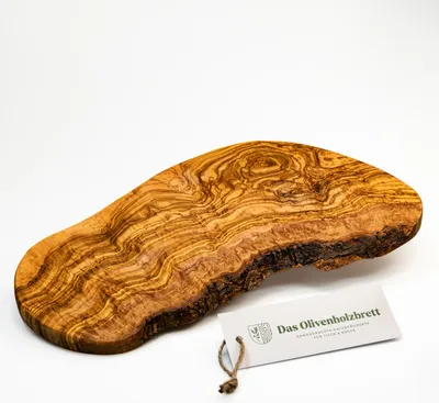 A single olive wood cutting board with a natural edge, displayed on a white background with a product tag attached.