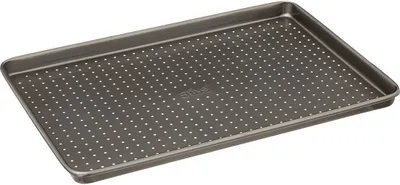 A perforated baking sheet on a gray background.