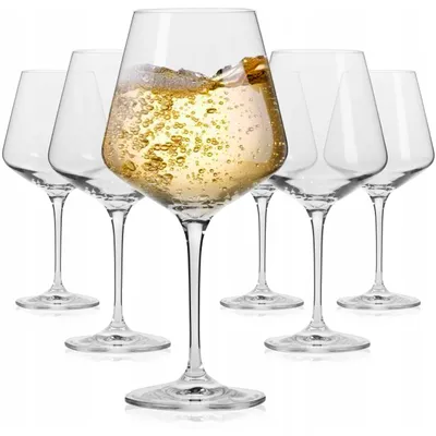 A group of six clear wine glasses, with one glass in the foreground filled with white wine.