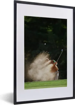 Produktbild von MuchoWow® Gerahmtes Poster Ein männlicher Golfer schlägt den Golfball aus dem Bunker auf das Grün 40x60 cm - Poster mit Schwarzem Bilderrahmen Wandposter Rahmen Foto Bilder - Poster in Rahmen