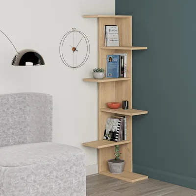 A corner shelf unit with books and decor is shown next to a chair and a clock on the wall.