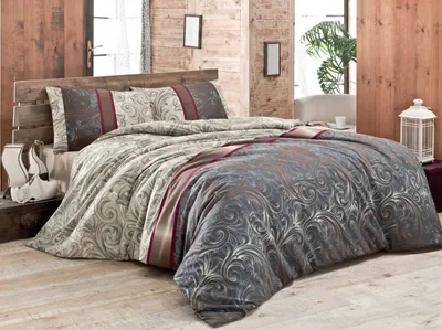 A beautifully made bed with a duvet and pillows in a rustic bedroom setting.