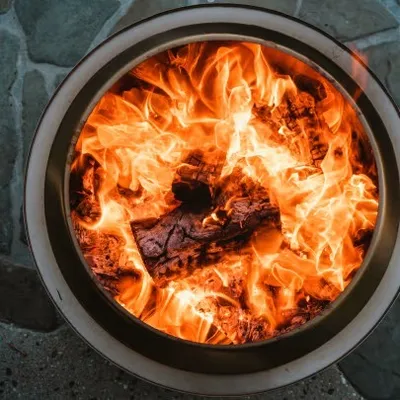A close-up view of a fire pit with burning logs.