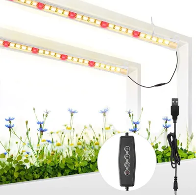 Two LED grow lights are shown above a bed of green plants and small flowers. A USB power cord and a remote control are also visible.