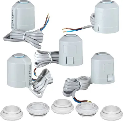 A collection of white thermostatic radiator valve actuators and matching adapters, arranged on a white background.