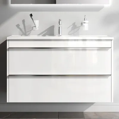 A modern white bathroom vanity with a sink and faucet.