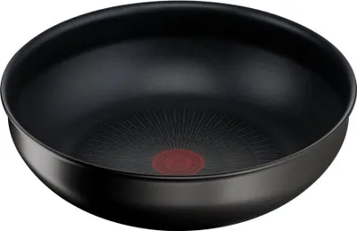A black wok or frying pan is shown from a slightly elevated angle against a white background.