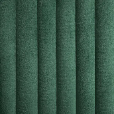 A close-up view of a green velvet fabric with vertical channel tufting.