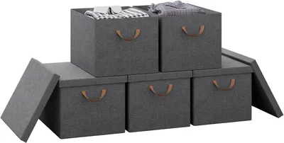 A set of five grey fabric storage boxes with brown handles are stacked and arranged on a white background.