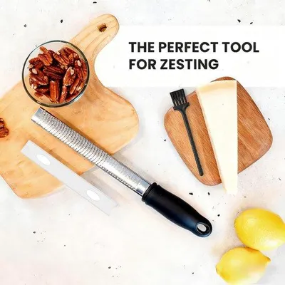 Produktbild von Unyqoos® Edelstahl-Multifunktionsreibe – ergonomischer Griff, 5 Fingerschützer & Reinigungsbürste, spülmaschinengeeignet, für Käse, Zitrus & Ingwer