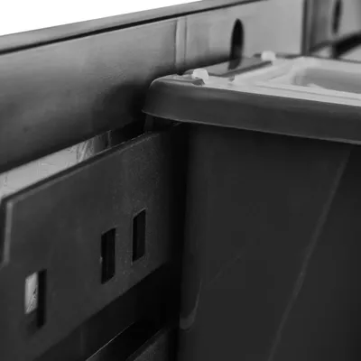 Close-up of a black plastic storage bin and its mounting system.