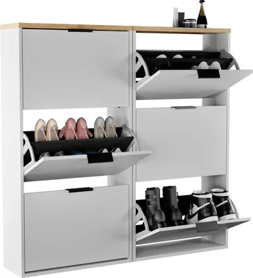 A white and gray shoe cabinet with a wood-tone top, displaying various shoes in its open compartments.