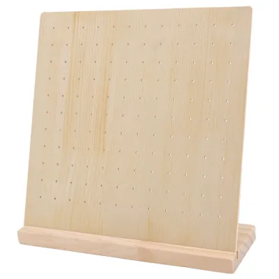 A wooden earring display stand with multiple holes for organizing earrings.