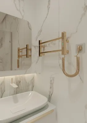 A bathroom with a sink, mirror, and a gold electric towel warmer.