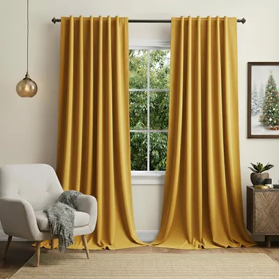 A living room scene with yellow curtains, a chair, and a side table.