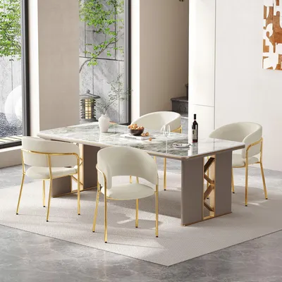 A dining room setting with a marble-top dining table and four beige chairs with gold legs.