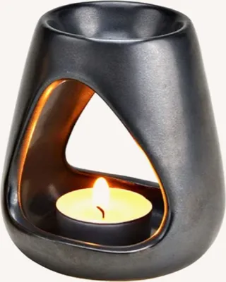 Eine silberne Duftlampe. Form ist organisch und fließend mit einer Aussparung in Form eines Dreiecks