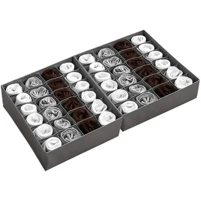A product shot of a gray fabric drawer organizer with 24 cells, filled with rolled-up socks or other small accessories in white, gray, and brown.