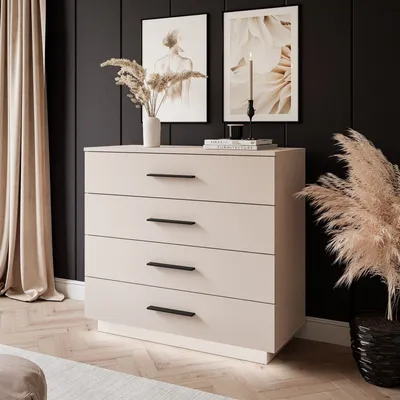 A modern bedroom setting with a beige dresser, curtains, and artwork.