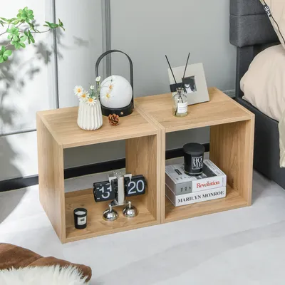 Two wooden cube shelves are placed next to a bed, decorated with various items.