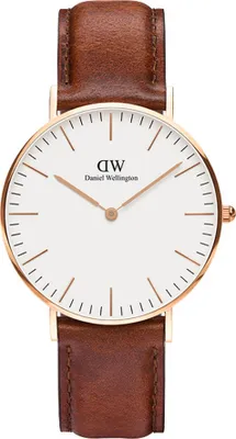 A close-up studio shot of a Daniel Wellington watch with a white face and a brown leather strap.