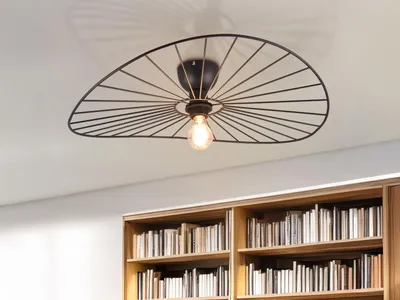A ceiling light fixture is shown above a bookshelf filled with books.