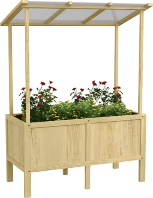 A wooden raised garden bed with a clear plastic lid, filled with red and green plants.