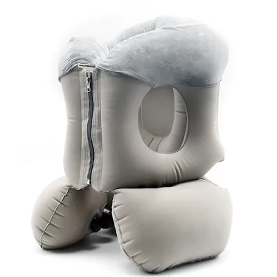 An inflatable travel pillow with a face hole and a zipper.