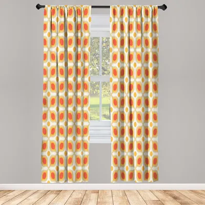 Two curtains with a geometric pattern hang in front of a window.