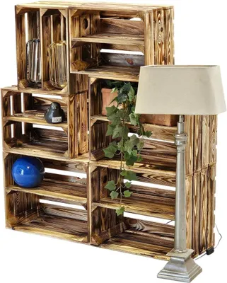A set of wooden crates arranged as shelving, with a lamp and decorative items.