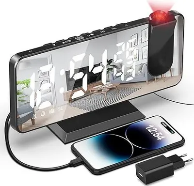 A digital alarm clock with a projector and a smartphone charging.