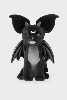 A black plush toy demon with large ears, wings, and a crescent moon on its forehead, sitting against a plain light gray background.