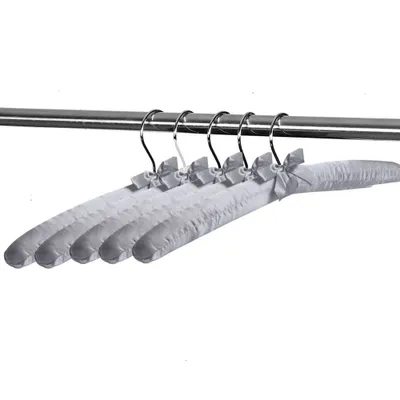 Several padded clothes hangers with bows are hanging on a metal rod.