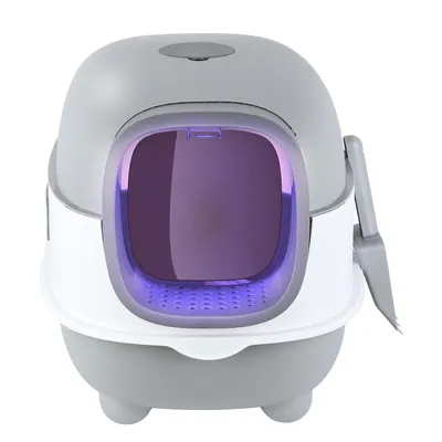 A modern, enclosed cat litter box with a purple-tinted entrance and a scoop attached to the side.