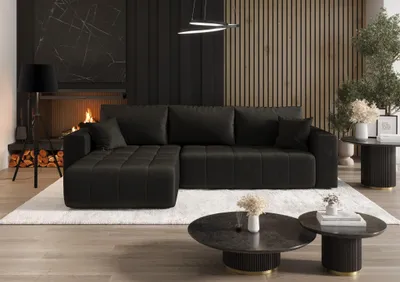 A modern living room with a dark gray sectional sofa, fireplace, and coffee tables.