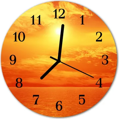 A round wall clock with a sunset over the ocean as its background.