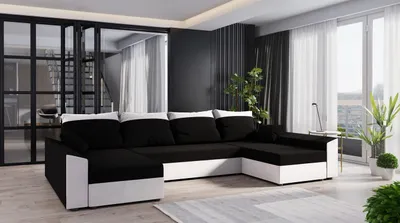 A modern living room with a U-shaped couch, large windows with curtains, and plants.