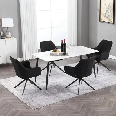 A dining room scene with a white table and four black chairs.