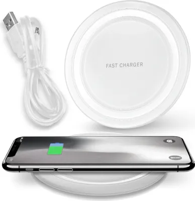A white wireless charging pad with a smartphone on it, and a USB cable next to it.