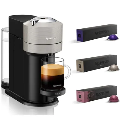 A Nespresso coffee machine with a cup of coffee and several boxes of coffee capsules.