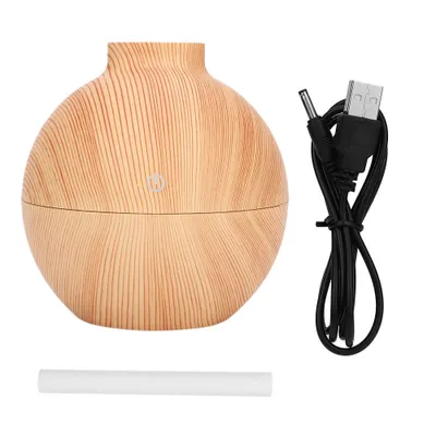 A mini essential oil diffuser with a wood grain finish, a USB cable, and a filter stick, presented on a white background.
