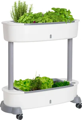 A two-tiered indoor/outdoor planter with wheels, containing various herbs and leafy greens.