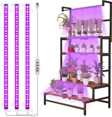 A set of three LED plant grow light strips and a multi-tiered plant stand filled with various potted plants, illuminated by the purple grow lights.