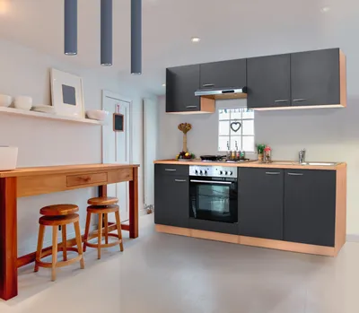 A modern kitchen with gray cabinets and a wooden countertop and bar.