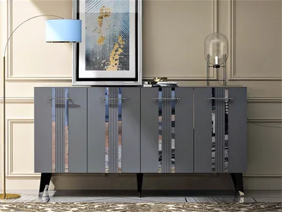 A modern living room setting with a grey sideboard, a floor lamp, and artwork.